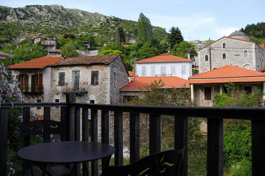 Μπαλκόνι με τραπεζάκι και θέα στα πέτρινα σπίτια της Στεμνίτσας